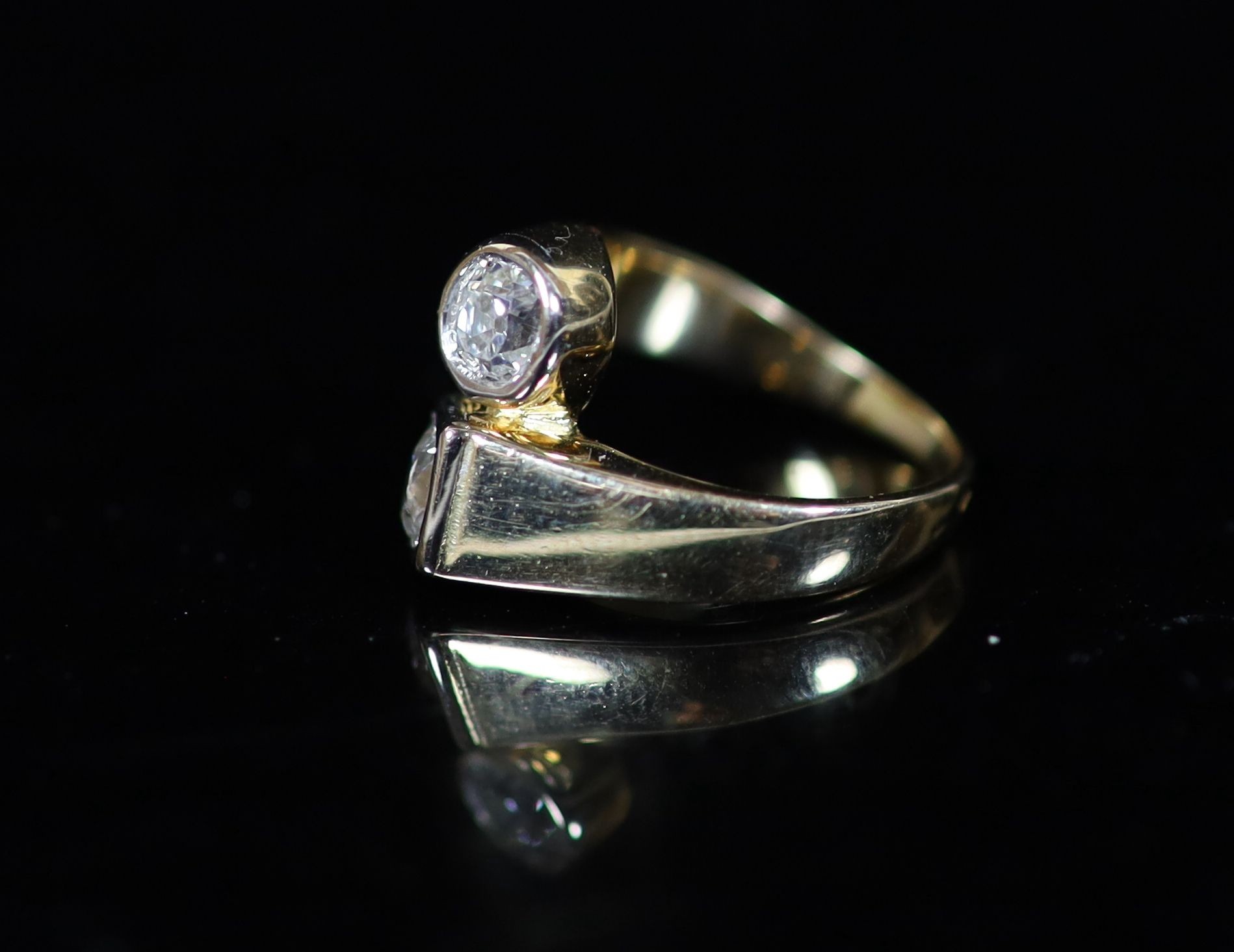 A Continental gold and collet set two stone diamond crossover ring